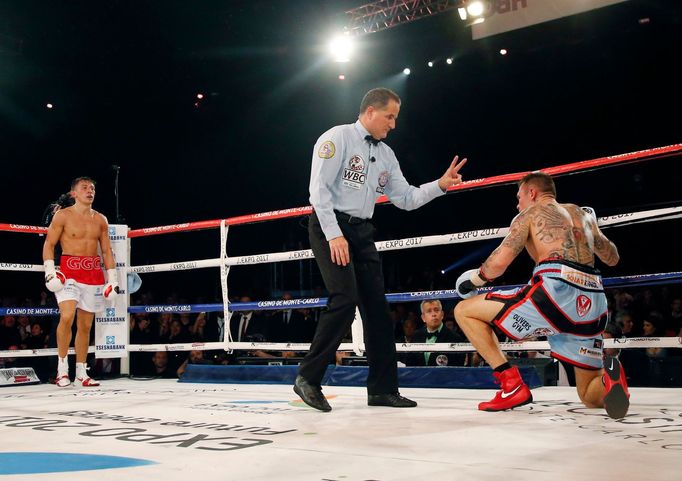 World champion Gennadiy Golovkin of Kazakhstan (L) looks at Martin Murray of England (R), after knocking him down, during the WBA-WBC-IBO Middleweight World Championship