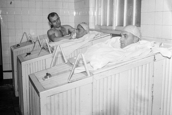 Pacienti v parní skříni. Lázeňská péče v pavilonu V.. Archivní fotografie z lázní v Karlových Varech z roku 1947.