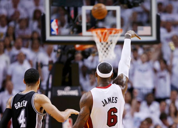 Miami Heat's LeBron James (R) shoots a three point basket while being guarded by San Antonio Spurs' Danny Green during the sceond quarter in Game 7 of their NBA Finals ba