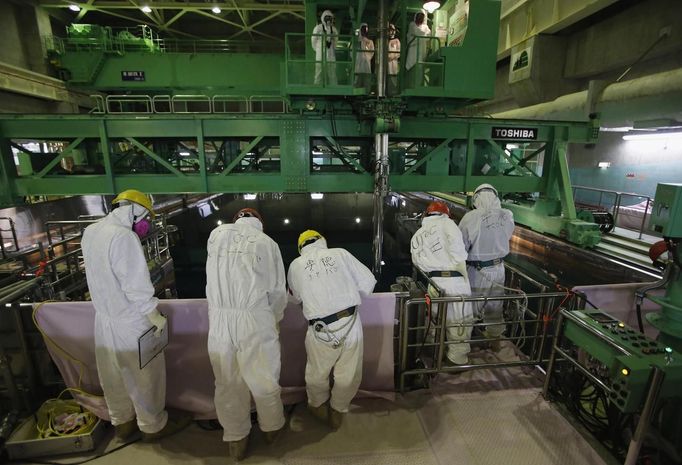 Workers wearing protective suits and masks are seen next to the spent fuel pool inside the Common Pool Building, where all the nuclear fuel rods will be stored for decommissioning, at Tokyo Electric Power Co. (TEPCO)'s tsunami-crippled Fukushima Daiichi nuclear power plant in Fukushima prefecture, March 6, 2013, ahead of the second-year of anniversary of the March 11, 2011 tsunami and earthquake. Members of the media were allowed into the plant on Wednesday ahead of the second-year anniversary of the tsunami and earthquake, which triggered the world's worst nuclear crisis since Chernobyl. REUTERS/Issei Kato (JAPAN - Tags: DISASTER ANNIVERSARY ENERGY) Published: Bře. 6, 2013, 9:43 dop.