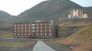 BARENTSBURG (Svalbard) - Nad opuštěným obytným domem ční ambasáda Ruské federace, jediný oplocený dům ve městě. Když však napadne sníh, plot se ztratí.