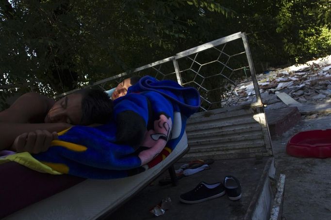 Jesus Gabarri (L) and his cousin Antonio Echevarria sleep on an open van next to the debris of the house where they used to live at the Spanish gypsy settlement of Puerta de Hierro outside Madrid August 1, 2012. Fifty-four families have been living in Puerta de Hierro, on the banks of the Manzanares river for over 50 years. Since the summer of 2010, the community has been subject to evictions on the grounds that the dwellings are illegal. Families whose houses have been demolished, move in with relatives whose houses still remain while the debris keeps piling up around them as more demolitions take place. Picture taken August 1, 2012. REUTERS/Susana Vera (SPAIN - Tags: SOCIETY) ATTENTION EDITORS - PICTURE 24 OF 31 FOR PACKAGE 'GYPSY SITE DEMOLISHED' SEARCH 'GYPSY SITE' FOR ALL IMAGES Published: Lis. 5, 2012, 4:12 odp.