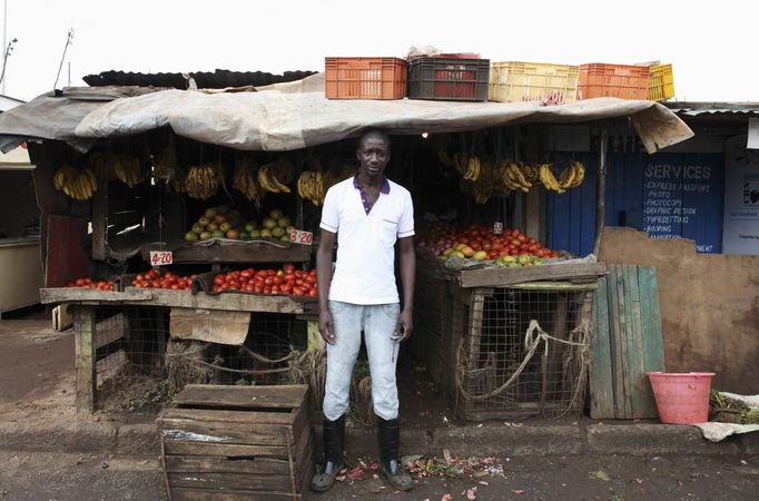 Karl Moi Okoth, a 27 year-old vegetable and fruit seller, poses for a picture in front of his makeshift shop in Nairobi's Kibera slum in the Kenyan capital April 30, 2012. Okoth studied psychology and chemistry at Day Star University where he received a degree in psychology. He has been searching for permanent employment for four years but has decided to make a living working in the slums for the last eight months.