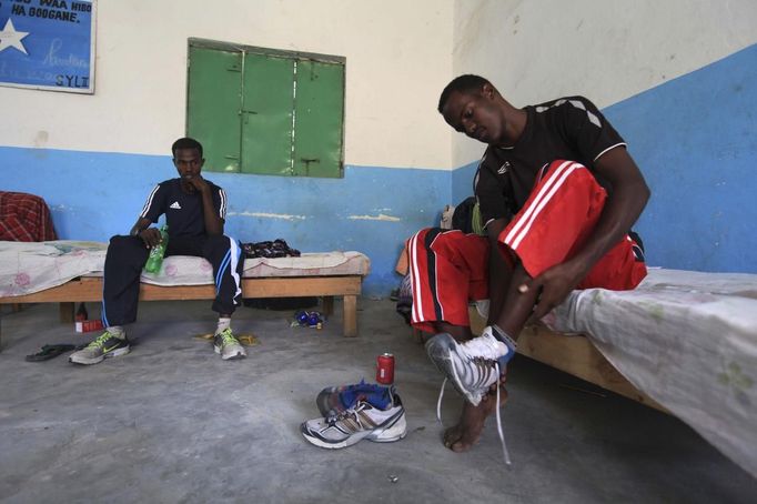 Somali athletes remove their shoes inside their room after a training session as part of their preparations for the 2012 London Olympic Games in Somalia's capital Mogadishu in this March 14, 2012 file photo. Training in a bullet-riddled stadium where the remains of a rocket propelled grenade lies discarded on the track's edge counts as progress for Somali Olympic hopeful Mohamed Hassan Mohamed. A year ago, Mogadishu's Konis stadium was a base for Islamist militants and a work out meant at times running through the streets, dodging gun-fire and mortar shells in one of the world's most dangerous cities. To match OLY-SOMALIA-HOPES/ REUTERS/Feisal Omar/Files (SOMALIA - Tags: SPORT ATHLETICS OLYMPICS) Published: Čer. 11, 2012, 6:36 dop.