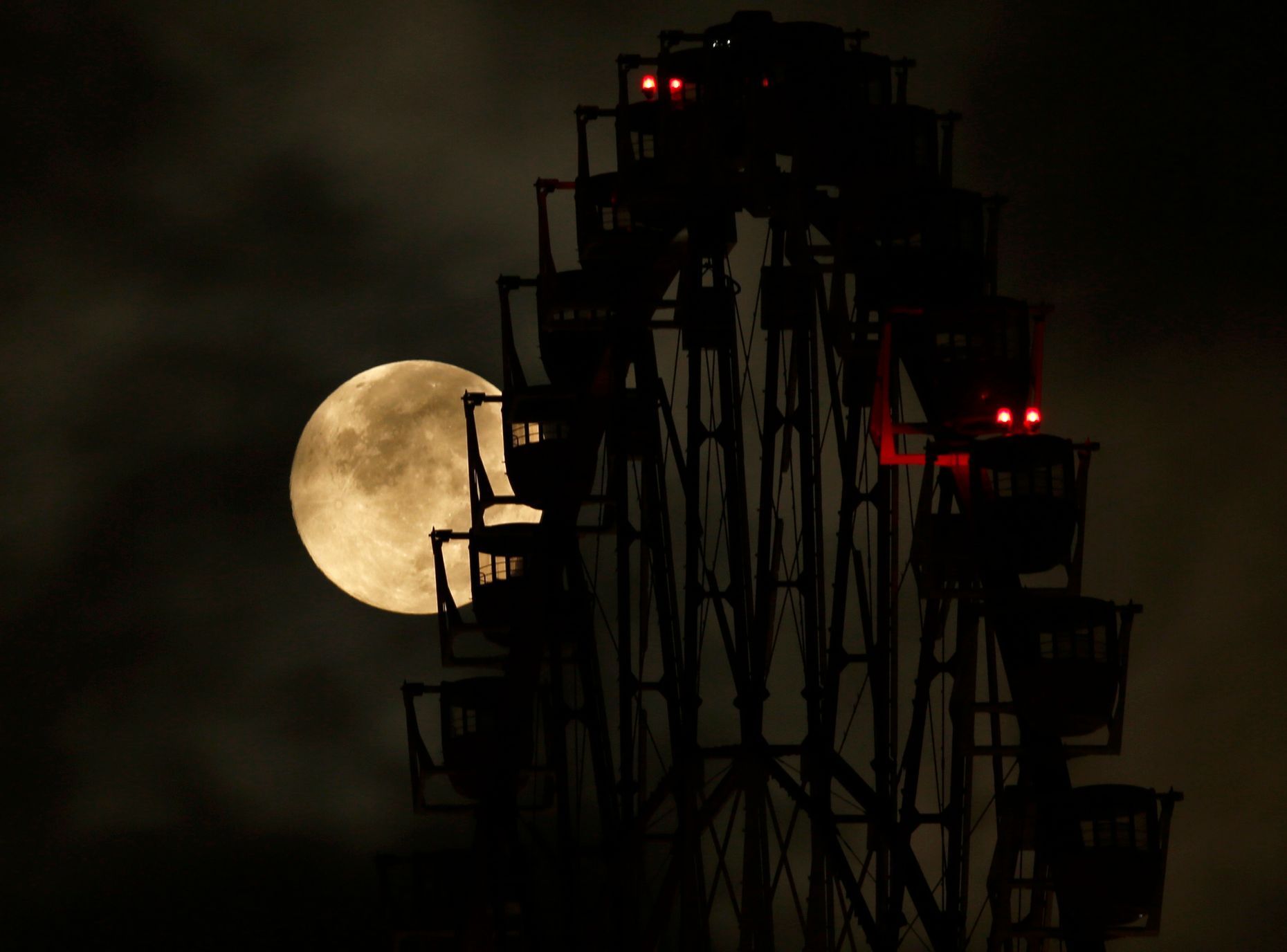 The supermoon is seen behind a ferris wheel in Tokyo