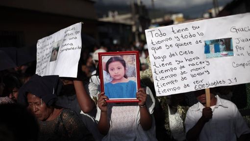 People hold a picture of 8-year-old Evelyn Yanisa Saquij Bin on the streets of Tactic, in the Alta Verapaz region, some 189 km (117 miles) from Guatemala City, September 14, 2012. Angry villagers in Guatemala killed a man by setting fire to him after he hacked Saquij Bin and 13-year-old Juan Armando Coy Cal to death with a machete in a school on September 12. The two children were buried today in a municipal cemetery. REUTERS/Jorge Dan Lopez (GUATEMALA - Tags: CRIME LAW SOCIETY TPX IMAGES OF THE DAY) Published: Zář. 15, 2012, 4:30 dop.