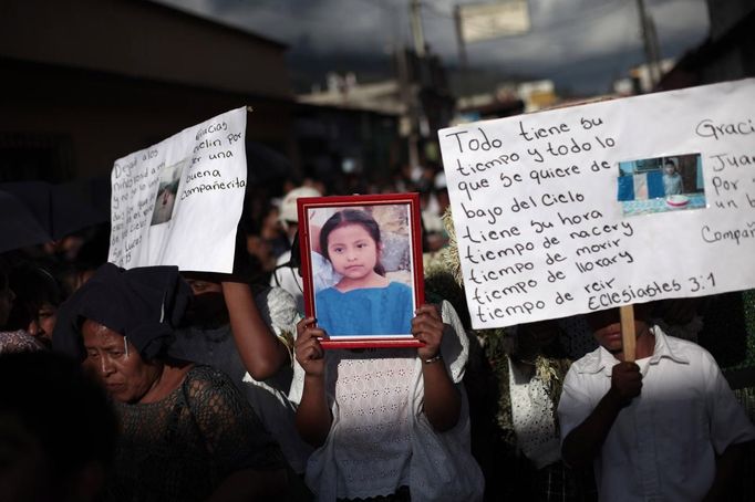 People hold a picture of 8-year-old Evelyn Yanisa Saquij Bin on the streets of Tactic, in the Alta Verapaz region, some 189 km (117 miles) from Guatemala City, September 14, 2012. Angry villagers in Guatemala killed a man by setting fire to him after he hacked Saquij Bin and 13-year-old Juan Armando Coy Cal to death with a machete in a school on September 12. The two children were buried today in a municipal cemetery. REUTERS/Jorge Dan Lopez (GUATEMALA - Tags: CRIME LAW SOCIETY TPX IMAGES OF THE DAY) Published: Zář. 15, 2012, 4:30 dop.