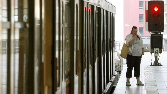 A passenger stands beside a local train during a warning strike at Berlins Alexanderplatz station August 9, 2007. Local rail transport in Hamburg and Berlin is disrupted by warning strikes again on Thursday when workers in the rebellious train drivers union GDL walked off the job during the morning rush hour. REUTERS/Arnd Wiegmann (GERMANY)