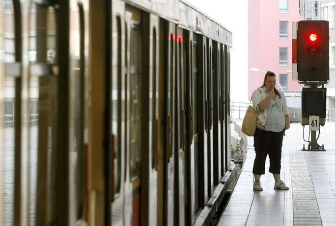 A passenger stands beside a local train during a warning strike at Berlins Alexanderplatz station August 9, 2007. Local rail transport in Hamburg and Berlin is disrupted by warning strikes again on Thursday when workers in the rebellious train drivers union GDL walked off the job during the morning rush hour. REUTERS/Arnd Wiegmann (GERMANY)