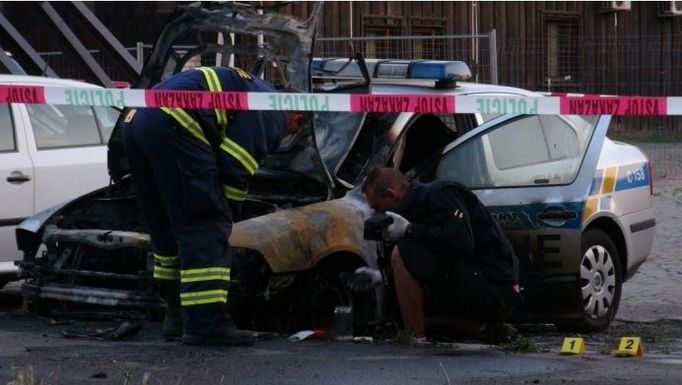 Policejní auto zapálené uskupením Síť revolučních buněk.