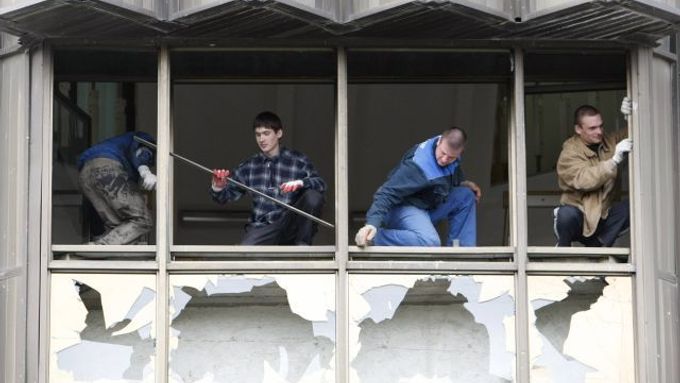 Dělníci uklízejí a opravují sídlo prezidentav Kišiněvě, které při povolebních protestech zdemolovalo protikomunističtí demonstranti.