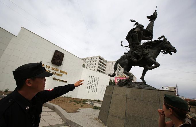 Ariunbold (L) and Uranjargal, leaders of the Mongolian neo-Nazi group Tsagaan Khass, stand next to a statue of Chingunjav, a Mongolian national hero, in Ulan Bator June 22, 2013. The group has rebranded itself as an environmentalist organisation fighting pollution by foreign-owned mines, seeking legitimacy as it sends Swastika-wearing members to check mining permits. Over the past years, ultra-nationalist groups have expanded in the country and among those garnering attention is Tsagaan Khass, which has recently shifted its focus from activities such as attacks on women it accuses of consorting with foreign men to environmental issues, with the stated goal of protecting Mongolia from foreign mining interests. This ultra-nationalist group was founded in the 1990s and currently has 100-plus members. Picture taken June 22, 2013. REUTERS/Carlos Barria (MONGOLIA - Tags: POLITICS ENVIRONMENT BUSINESS SOCIETY EMPLOYMENT) ATTENTION EDITORS: PICTURE 09 OF 25 FOR PACKAGE 'MONGOLIA'S ENVIRONMENTAL NEO-NAZIS'. TO FIND ALL IMAGES SEARCH 'TSAGAAN KHASS' Published: Čec. 2, 2013, 9:58 dop.