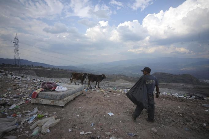 A garbage collector looks for recyclable waste at a municipal dump site in Tegucigalpa