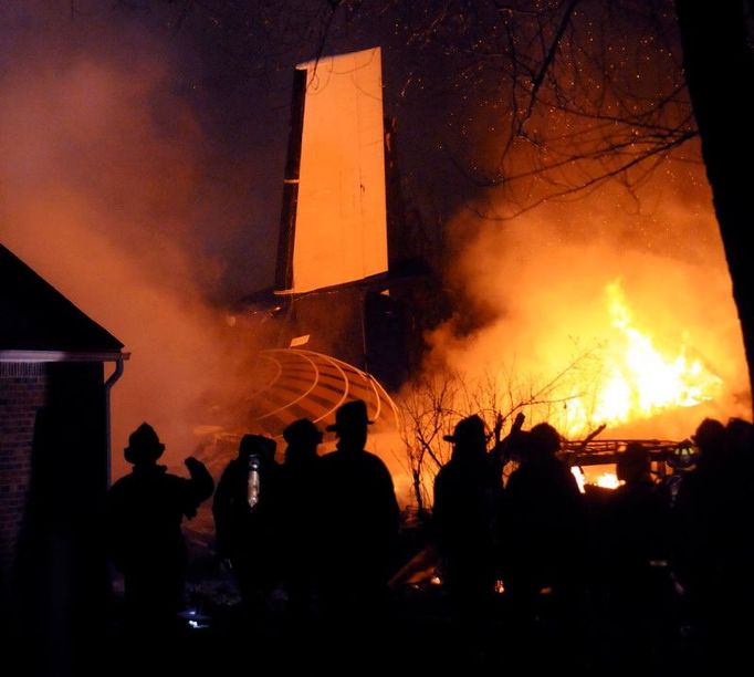 Hasiči se snaží zlikvidovat požár domu na předměstí Buffala, na který se zřítilo letadlo s bezmála padesáti lidmi na palubě.