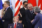 Francouzský prezident jaques Chirac se zdraví s japonským premiérem Džuničirem Koizumim. Vedle se usmívá americký prezident George Bush, v pozadí stojí britský premiér Tony Blair.