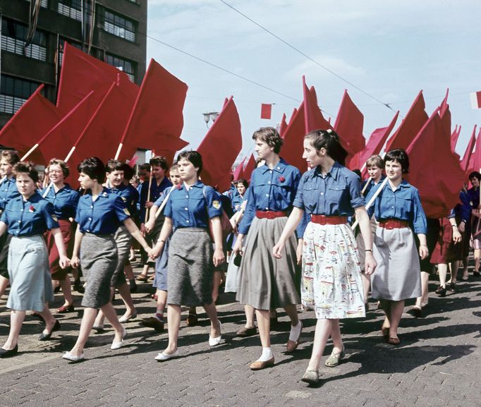 Členové FDJ pochodují s rudými vlajkami během prvomájových oslav v Drážďanech v roce 1959.