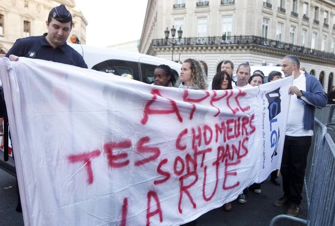 French Apple employees and unemployed former retailers demonstrate in front of an Apple store during the launching of the Iphone 5 in Paris September 21, 2012. Some 20 former staffers of independent Apple distributors which closed after struggling to compete with Apple's own stores gathered in front of its flagship Paris store to protest the technology giant's policies. The slogan reads "Apple, your unemployed are in the street". REUTERS/Jacky Naegelen (FRANCE - Tags: BUSINESS TELECOMS EMPLOYMENT) Published: Zář. 21, 2012, 9:21 dop.