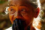 Příslušnice kmene Kajangů před hlasováním. Má smysl máčet jí prst do inkoustu, aby se označilo, že už volila? Žena má ruce zcela zbarvené od tradičního způsobu batikování, kterým se ženy tohoto kmene živí. Snímek pochází ze souostroví Jižní Sulawesi.