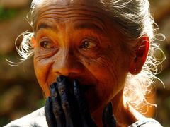 Příslušnice kmene Kajangů před hlasováním. Má smysl máčet jí prst do inkoustu, aby se označilo, že už volila? Žena má ruce zcela zbarvené od tradičního způsobu batikování.