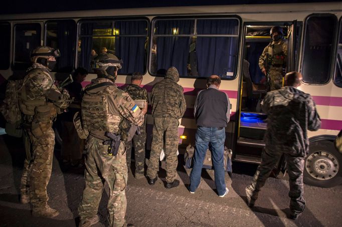 Členové proruských separatistů čekají čelem k autobusu na výměnu. Severně od Doněcku, východní Ukrajina, 12.9.2014