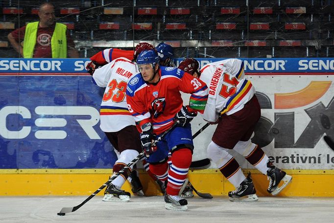 Hokejista Paul Szczechura ujíždí z klinče Zdeňku Bahenskému (vpravo) a Troyi Milamovi (vlevo) v přípravném utkání mezi Spartou Praha a pražským Lvem před sezónou 2012/13.