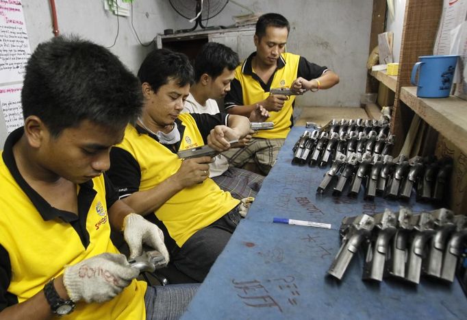 Former illegal gunsmiths check newly assembled pistols at Shooters Arms, a gun manufacturing company exporting different kinds of weapons to other countries, in Cebu city in central Philippines July 6, 2012. In the Philippines, they vote with their trigger fingers. Elections mean big business for illegal gunsmiths, who are looking forward to 2013 mid-term polls. With election-related violence commonplace, the Philippines imposes a ban on the carrying of guns for six months, from campaigning to the proclamation of winners. Picture taken July 6, 2012. To match Feature PHILIPPINES-GUNS/ REUTERS/Erik De Castro (PHILIPPINES - Tags: SOCIETY POLITICS BUSINESS CRIME LAW) Published: Čec. 29, 2012, 1:43 dop.