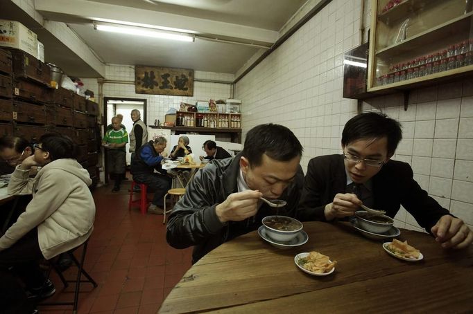 Customers eat snake soup at a snake soup shop in Hong Kong January 30, 2013. There are scores of people in Hong Kong who have through generations tamed snakes to make soup out of them, a traditional cuisine believed to be good for the health. Yet the people behind providing fresh snakes for the savoury meal thought to speed up the body's blood flow and keep it strong in the cold winter months may be doomed, with young people increasingly reluctant to take on a job they see as hard and dirty. Picture taken January 30, 2013. REUTERS/Bobby Yip (CHINA - Tags: ANIMALS FOOD SOCIETY) Published: Úno. 7, 2013, 2:01 odp.