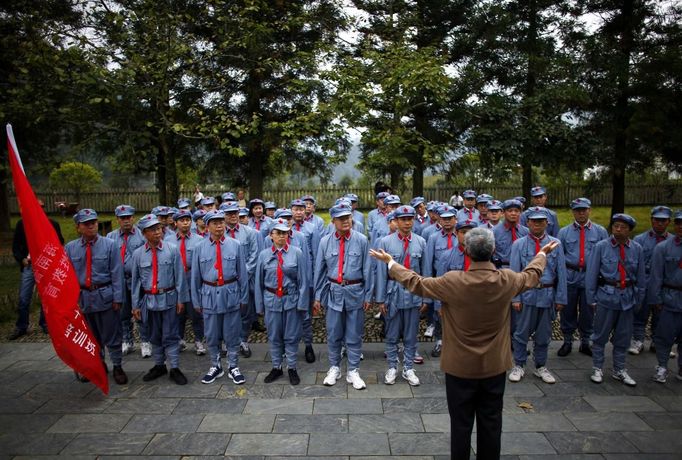 Mid-level government officials dressed in red army uniforms listen to a lesson as they visit an old house where former Chinese leader Mao Zedong used to live during their 5-day training course at the communist party school called China Executive Leadership Academy of Jinggangshan, in Jiangxi province, in this September 21, 2012 file photo. China's Communist Party has dramatically stepped up its training of the country's roughly 40 million party and government officials in the past decade. With public scrutiny of cadre behaviour growing via social media, the party is likely to call for continued, and deepened, cadre education at the upcoming 18th Party Congress. At the vanguard of this education drive, alongside a Central Party School in Beijing, are three "Executive Leadership Academies" which opened in 2005 for middle-ranking and senior officials in Shanghai, Yan'an and Jinggangshan. The curriculum covers Marxism, Leninism and Mao Zedong Thought, but students may also take finance courses, receive in-depth media training or role-play crisis management scenarios on everything from disease outbreaks to train wrecks. REUTERS/Carlos Barria/Files (CHINA - Tags: POLITICS SOCIETY) Published: Zář. 24, 2012, 2:46 odp.