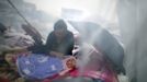 A woman looks at her child as they rest among the wreckage after Saturday's earthquake in Lingguan town of Baoxing county, Sichuan province, April 21, 2013. Rescuers struggled to reach a remote, rural corner of southwestern China on Sunday as the death toll climbs to 186 people dead and 11,393 injured, Xinhua News Agency reported. Picture taken April 21, 2013. REUTERS/China Daily (CHINA - Tags: DISASTER) CHINA OUT. NO COMMERCIAL OR EDITORIAL SALES IN CHINA Published: Dub. 22, 2013, 3:04 dop.