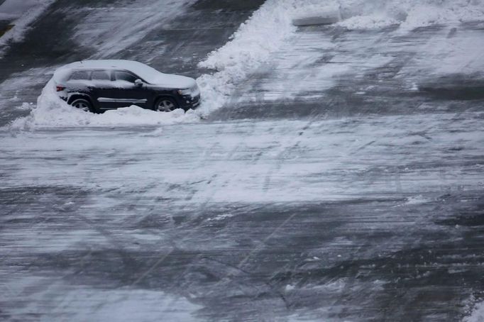 A car is seen atop a parking structure near Times Square in New York, February 9, 2013. A blizzard pummeled the Northeastern United States, killing at least one person, leaving hundreds of thousands without power and disrupting thousands of flights, media and officials said. REUTERS/Eric Thayer (UNITED STATES - Tags: ENVIRONMENT) Published: Úno. 9, 2013, 3:43 odp.