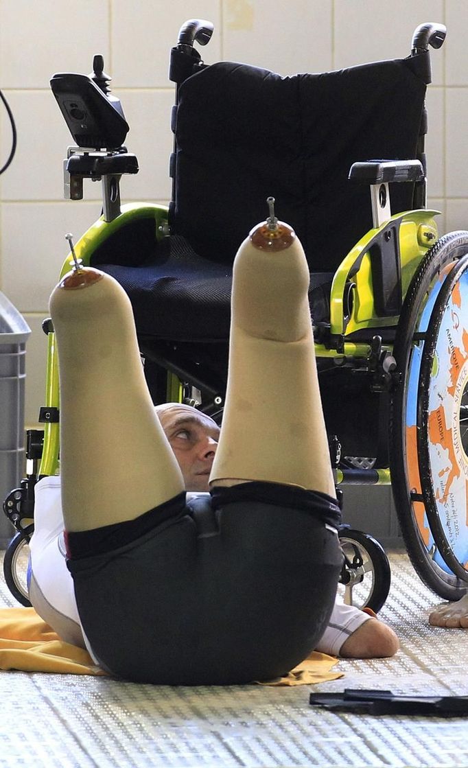 French athlete Philippe Croizon, whose arms and legs were amputated after an electric shock accident in March 1994, warms up before entering in a 33 metre (36 yard) deep pool, the world's deepest pool built to train professional divers, at Nemo33 diving centre in Brussels January 10, 2013. Croizon, who swam with adapted prostheses that had fins attached, broke a world record and became the first disabled person to dive to 33 metres, according to the organisers. REUTERS/Yves Herman (BELGIUM - Tags: SOCIETY SPORT DIVING) Published: Led. 10, 2013, 4:34 odp.