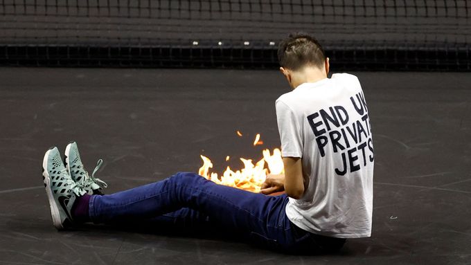 Tennis - Laver Cup - 02 Arena, London, Britain - September 23, 2022   A protester lights a fire on the court during the match between Team Europe's Stefanos Tsitsipas and