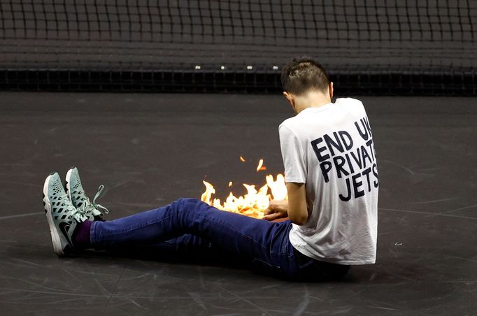 Tennis - Laver Cup - 02 Arena, London, Britain - September 23, 2022   A protester lights a fire on the court during the match between Team Europe's Stefanos Tsitsipas and