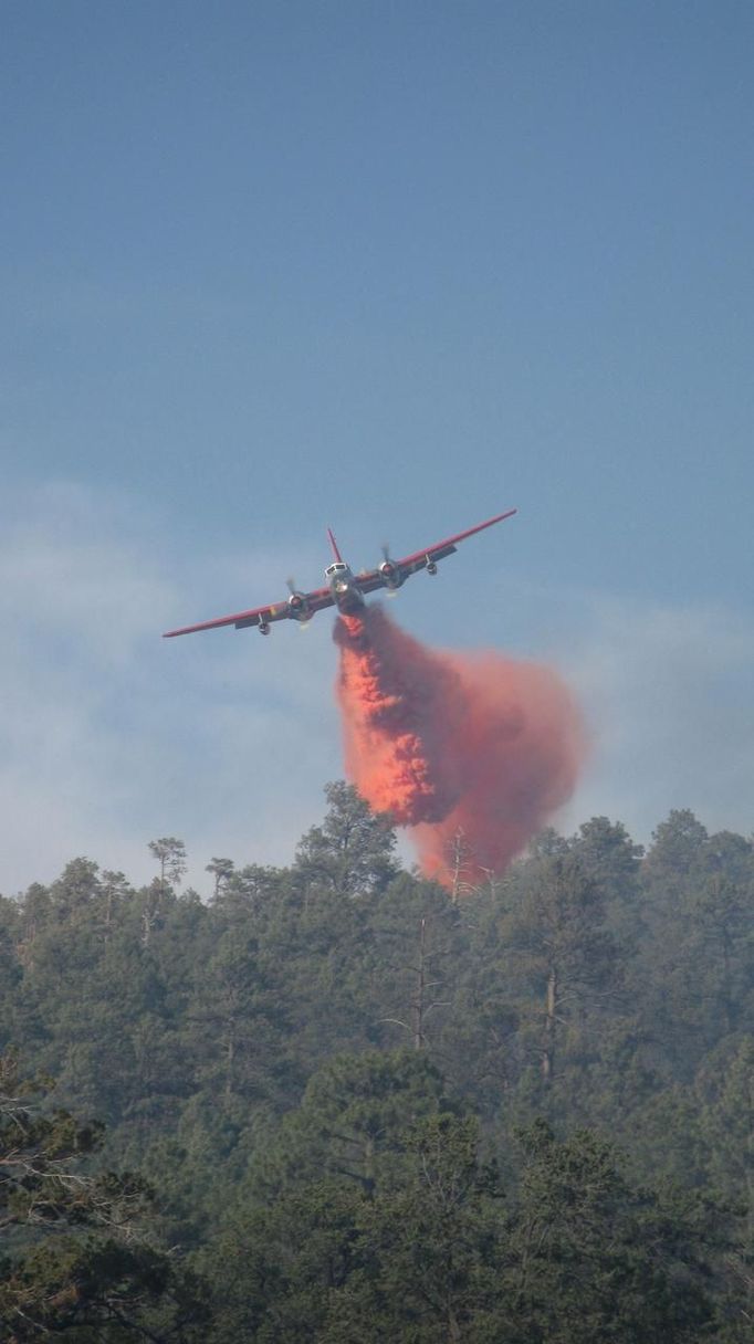 A P2V air tanker drops fire retardant on a section of Gila National Forest in southwest New Mexico in this U.S. Forest Service handout photo taken June 2 and released June 5, 2012. The so-called Whitewater-Baldy Complex fire was ignited by lightning on May 16 in the rugged high country of New Mexico's Gila National Forest AND has now scorched more territory than any other recorded blaze in the state's history, over 255,000 acres. REUTERS/Aaron Baldridge/USFS Gila National Forest/Handout (UNITED STATES - Tags: ENVIRONMENT DISASTER) THIS IMAGE HAS BEEN SUPPLIED BY A THIRD PARTY. IT IS DISTRIBUTED, EXACTLY AS RECEIVED BY REUTERS, AS A SERVICE TO CLIENTS. FOR EDITORIAL USE ONLY. NOT FOR SALE FOR MARKETING OR ADVERTISING CAMPAIGNS Published: Čer. 6, 2012, 3:05 odp.