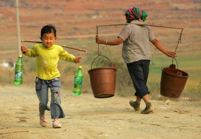 Chlapec nesoucí plastové lahve s vodou ve vesnici Dashiqiao v okrese Shilin, provincii Yunnan, 22. března 2010. Krutá sucha napříč rozsáhlým územím jihozápadní Číny nepříznivě ovlivňují více než 50 milionů lidí, přičemž předpovědi nejsou v krátkodobém měřítku optimistické.