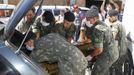 Army soldiers carry a coffin containing the body of a victim of the fire at Boate Kiss nightclub in the southern city of Santa Maria, 187 miles (301 km) west of the state capital of Porto Alegre, January 27, 2013. A fire in a nightclub killed at least 245 people in southern Brazil on Sunday when a band's pyrotechnics show set the building ablaze and fleeing patrons were unable to find the emergency exits in the ensuing panic, officials said. The blaze in the southern city of Santa Maria was started when a band member or someone from its production team ignited a flare, which then set fire to the ceiling, said Luiza Sousa, a civil police official. The fire spread "in seconds," she said. An estimated 500 people were in the Boate Kiss nightclub when the fire broke out early on Sunday, and many were unable to find the exits as dark smoke quickly filled the room. At least one exit was locked, trapping hundreds inside to die, many from asphyxiation as they inhaled smoke, police said. REUTERS/Edison Vara (BRAZIL - Tags: DISASTER MILITARY) Published: Led. 27, 2013, 8:01 odp.