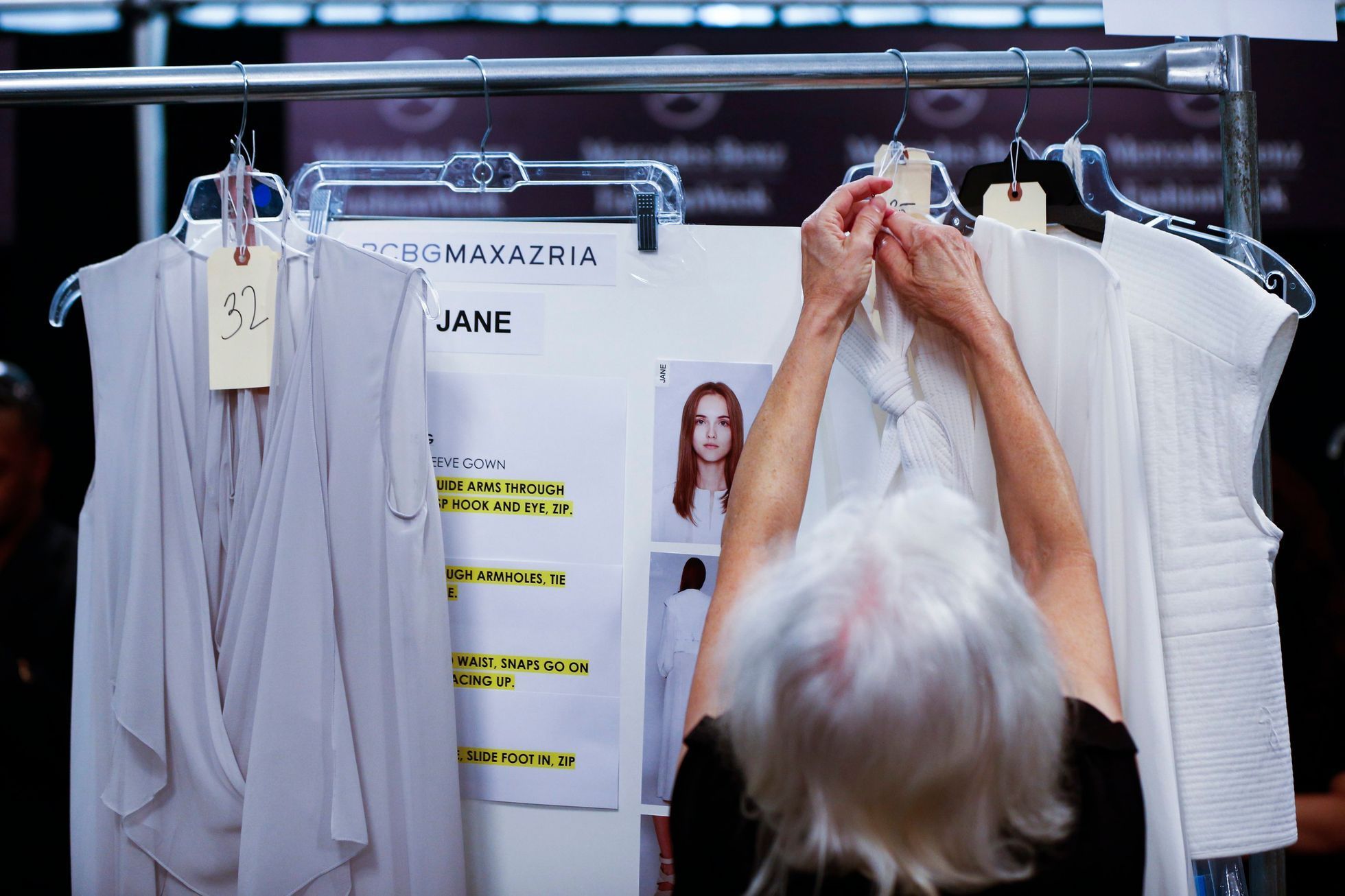 A worker prepares clothing backstage before a showing of the BCBG Max Azria collection during New York Fashion Week