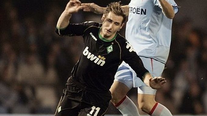 Miroslav Klose z Werderu Brény (v černém) atakovaný hráčem Viga Pablem Garciou.