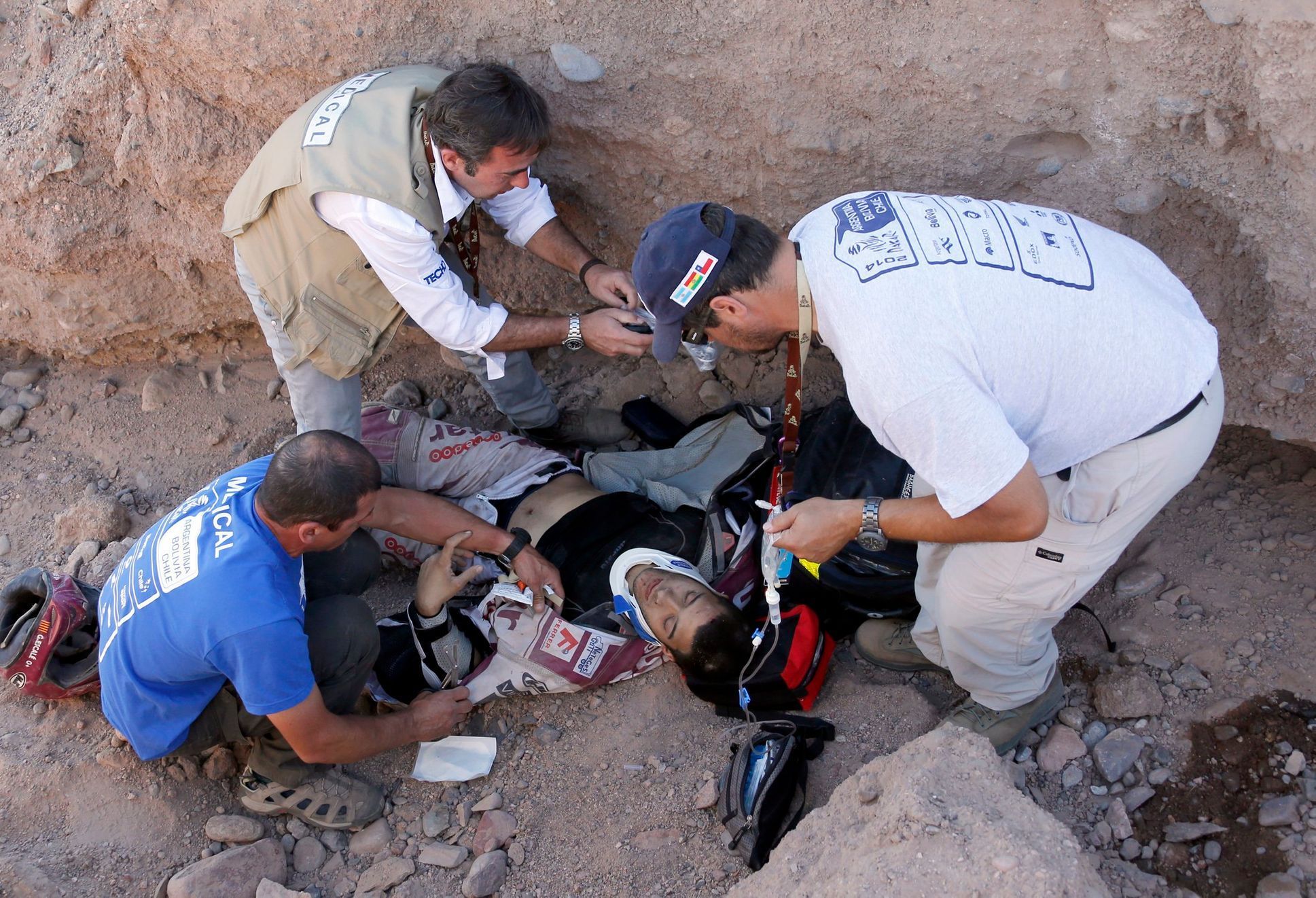 Dakar Rally medical assistance members provide aid to Suzuki rider Gilbert Escale of Spain after he was injured in a crash during the fifth stage of the Dakar Rally 2014 from Chilecito to Tucuman