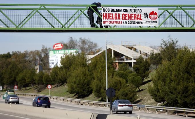 Esteban Carrasco sets up a banner calling for a general strike, on a bridge in Pinto, near Madrid, November 12, 2012. Spain's two largest labour unions had called a general strike for November 14, the second against the conservative government since they took power in December and coinciding with industrial action in Portugal on the same day. The banner reads, "They leave us without future. General Strike. There are culprits, there are solutions." REUTERS/Sergio Perez (SPAIN - Tags: BUSINESS EMPLOYMENT POLITICS CIVIL UNREST) Published: Lis. 12, 2012, 2:06 odp.