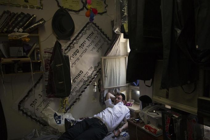 An ultra-Orthodox Jewish man rests in his room at Jerusalem's Mir Yeshiva, the largest Jewish seminary in Israel July 4, 2012. The ultra-Orthodox Jews have gone from being a tiny minority in Israel's mostly secular society to its fastest-growing sector, now about 10 percent of the 7.8 million population. They are exempt from military duty in Israel but draft deferments and state subsidies for the ultra-Orthodox have become a divisive political issue in Israel, where the government must decide a new law by August to ensure more of them do military service. Picture taken July 4, 2012. REUTERS/Ronen Zvulun (JERUSALEM - Tags: POLITICS RELIGION MILITARY EDUCATION) ATTENTION EDITORS - PICTURE 2 OF 21 FOR PACKAGE "ISRAEL'S ULTRA-ORTHODOX". SEARCH "ULTRA-ORTHODOX" FOR ALL PICTURES Published: Čec. 6, 2012, 9:59 dop.