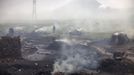 A man walks past heaps of burning coal to make it for domestic use such as for cooking purposes at Dhanbad district in the eastern Indian state of Jharkhand September 20, 2012. With oil and gas output disappointing and hydropower at full throttle, Asia's third-largest economy still relies on coal for most of its vast energy needs. About 75 percent of India's coal demand is met by domestic production and, according to government plans, that won't change over the next five years. Picture taken September 20, 2012. To match INDIA-COAL/ REUTERS/Ahmad Masood (INDIA - Tags: BUSINESS EMPLOYMENT ENERGY SOCIETY ENVIRONMENT) Published: Říj. 21, 2012, 10:03 odp.