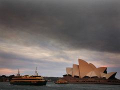 Ferries sail past the Sydney Opera House as smoke from bushfires can be seen above, in Sydney October 20, 2013.