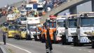 A rescue worker gestures in front of recovery trucks lined up to collect over 100 vehicles involved in multiple collisions, which took place in dense fog during the morning rush hour, on the Sheppey Bridge in Kent, east of London, September 5, 2013. Eight people were seriously injured and dozens hurt in the multiple crashes.