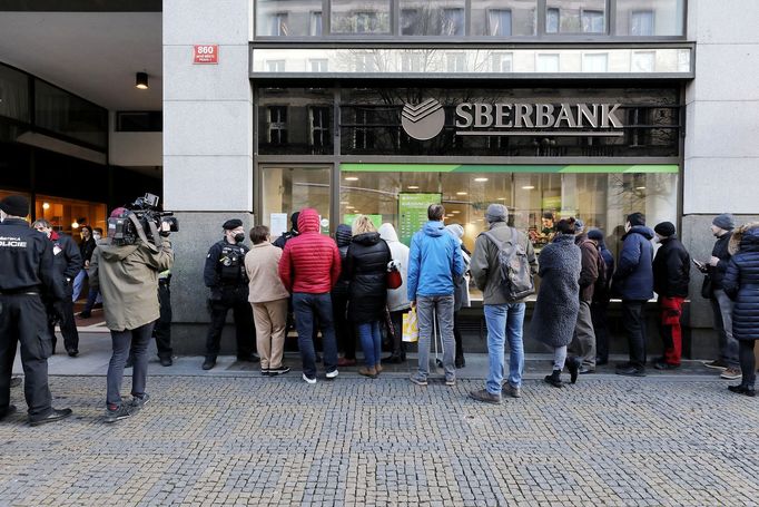 Fronta lidí u Sberbank na pražských Příkopech. Vchod hlídá městská policie. 24. 2. 2022