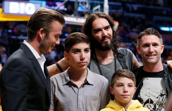 Fotbalista David Beckham a zpěvák Russell Brand na utkání NBA 2012/13 mezi Los Angeles Lakers a Dallasem Mavericks.