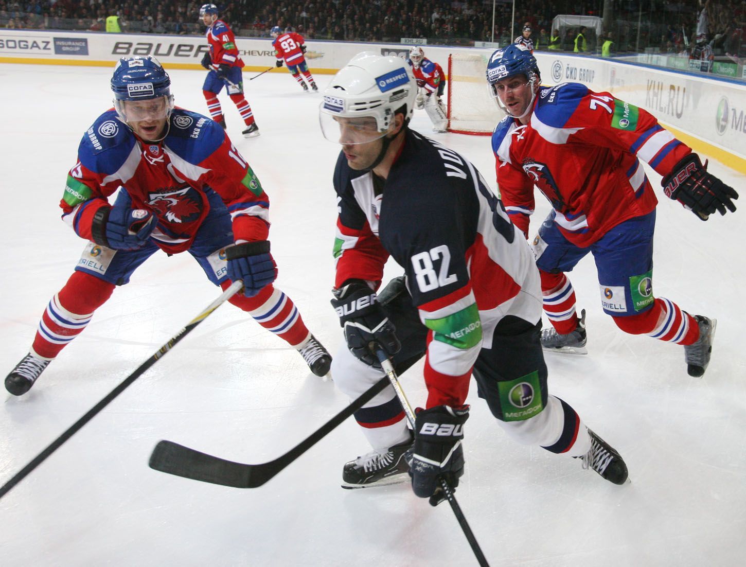 Hokejisté Lva Praha Jiří Novotný a Nathan Oystrick dohánějí Michala Vondrku v utkání KHL 2012/13 proti Slovanu Bratislava.