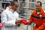 Cenný autogram. Lewis Hamilton se podepisuje na čepici.
