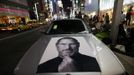 A portrait of Apple co-founder Steve Jobs is seen on a BMW car near people waiting for the release of iPhone 5 in front of Apple Store Ginza in Tokyo September 20, 2012. REUTERS/Toru Hanai (JAPAN - Tags: TRANSPORT BUSINESS SOCIETY TELECOMS) Published: Zář. 20, 2012, 12:06 odp.