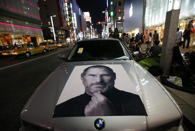 A portrait of Apple co-founder Steve Jobs is seen on a BMW car near people waiting for the release of iPhone 5 in front of Apple Store Ginza in Tokyo September 20, 2012. REUTERS/Toru Hanai (JAPAN - Tags: TRANSPORT BUSINESS SOCIETY TELECOMS) Published: Zář. 20, 2012, 12:06 odp.